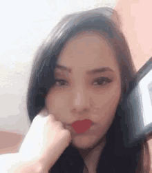a woman with red lipstick is making a funny face .