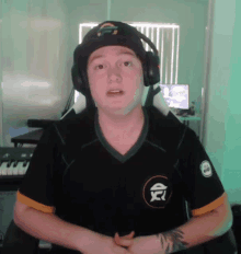 a man wearing headphones and a black shirt with a x on it