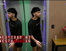 a man in a black shirt is standing in front of a mirror with the words vestidad on it