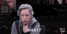 a woman with gray hair is making a face and says what
