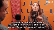 a woman is talking into a microphone and says " if anybody hands you this book you light it on fire in front of them "