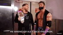 two wrestlers are standing next to each other and one of them is holding a wrestling championship belt .