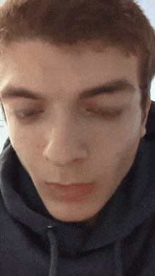 a close up of a man 's face wearing a hoodie