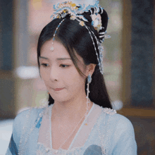 a woman wearing a blue and white costume with pearls on it