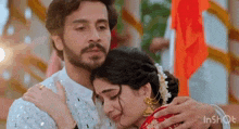 a man is hugging a woman who is crying while they are standing next to each other .