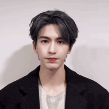 a young man wearing a black jacket and a white shirt has red lipstick on his mouth