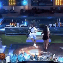 a man and a woman are dancing on a stage in front of a sign that says ' coca cola '