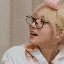 a woman wearing glasses and a pink curling iron on her head