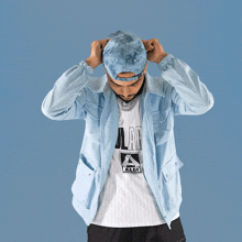 a man is wearing a light blue jacket and a white shirt that says aldi
