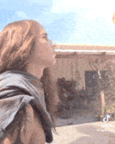 a woman with long hair is standing in front of a building with a sign that says tik tok