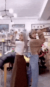 two girls are standing next to each other in a room with a christmas tree .
