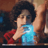 a young boy is looking at a minecraft movie item
