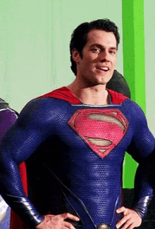 a man in a blue and red superman costume with his hands on his hips