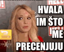 a woman with blonde hair is standing in front of a sign that says hvala im sto ime precenjuju