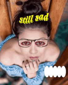 a woman wearing glasses with the words still sad above her