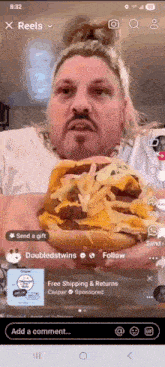 a man with a mustache is holding a large cheeseburger in his hands .