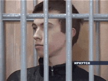 a man in a jail cell with the word irkutsk on the bottom right