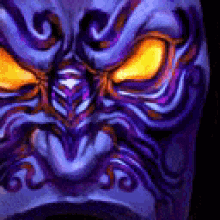 a close up of a purple and orange tiki mask with yellow eyes .