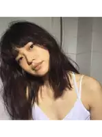 a woman wearing a white tank top is looking at the camera