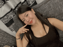 a woman is sitting on a couch with her hand on her chin