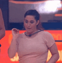 a woman in a pink shirt is dancing in front of a red background .