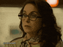 a woman wearing glasses and a scarf has the hashtag lialmeida05 on the bottom right