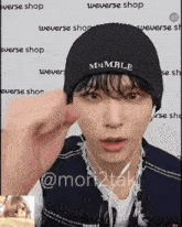 a man wearing a beanie and headphones is giving a middle finger