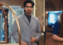 a man in a suit stands next to a woman in a blue dress