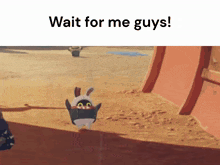 a penguin in a bunny costume is standing on a sandy beach .