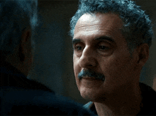 a man with a mustache is talking to another man and says i want to