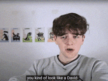 a young boy says you kind of look like a david in front of a wall with pictures of animals on it