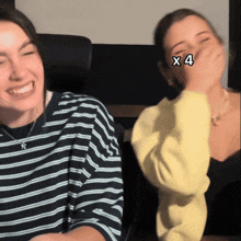 two women are laughing and one has the number 4 on her eye
