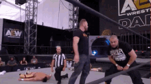 a wrestler is kneeling down in front of a sign that says all elite wrestling