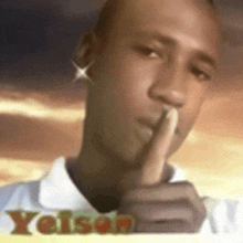 a man is holding his finger to his mouth and making a shhh sign .