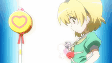 a yellow lollipop with a pink heart on it is being held by a girl