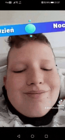 a close up of a boy 's face with his eyes closed on a phone screen .