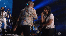 a man singing into a microphone in front of a screen that says songland