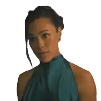 a woman wearing a green dress and earrings is looking to the side