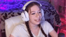 a young woman wearing headphones is sitting in a chair .