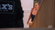a woman in a black tank top is standing next to a man in a black jacket with the word bravo on it .