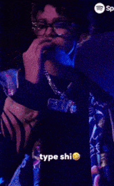 a man smoking a cigarette with a spotify logo behind him