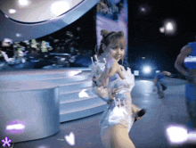 a woman in a white dress holds a microphone in her hand