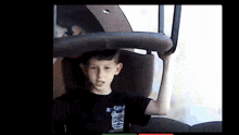 a boy wearing a shirt that says regina is holding a chair over his head