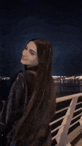 the woman is wearing a black leather jacket and a black top .