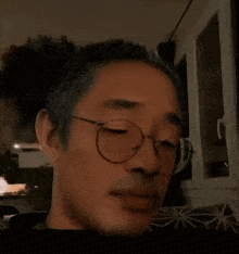 a close up of a person wearing glasses and a bun