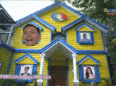 a yellow and blue house with a picture of a man and two women on the windows