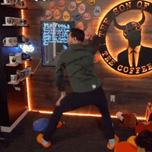 a man stands in front of a son of the coffee sign