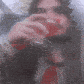 a man with a beard is drinking a glass of red wine