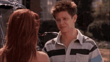 a man and a woman are looking at each other .