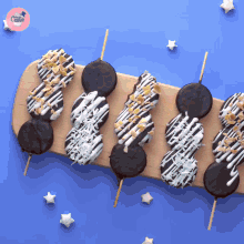 a wooden cutting board with chocolate covered cookies on sticks and the words cake on the corner